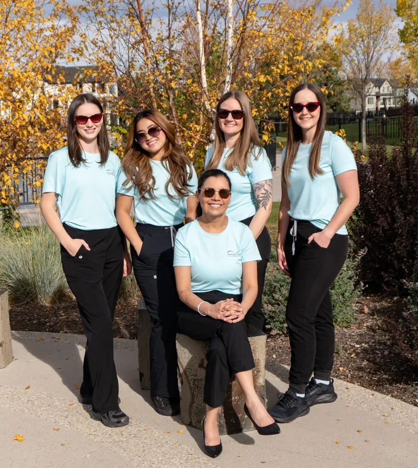 Five Mahogany Village Dental team members in sunglasses posing outdoors in the autumn
